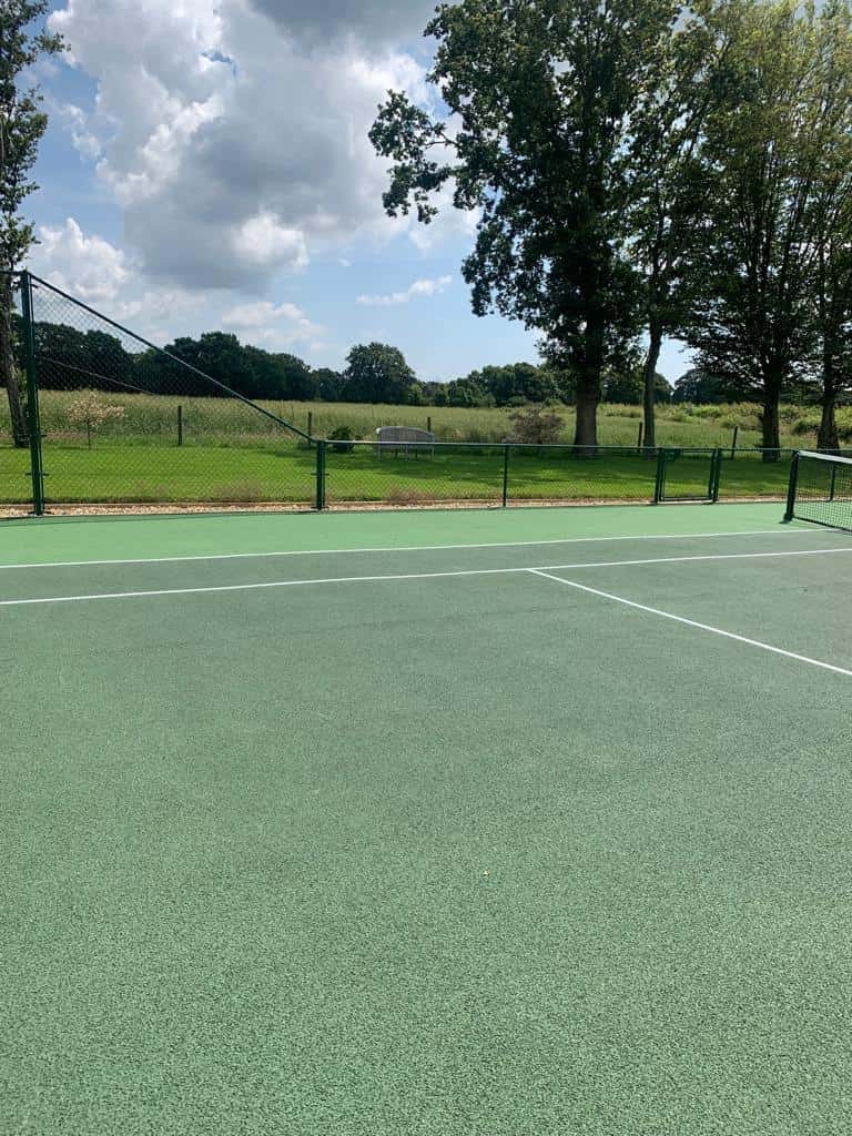 This is a photo showing a tennis court that has just been resurfaced. It now looks as good as new!